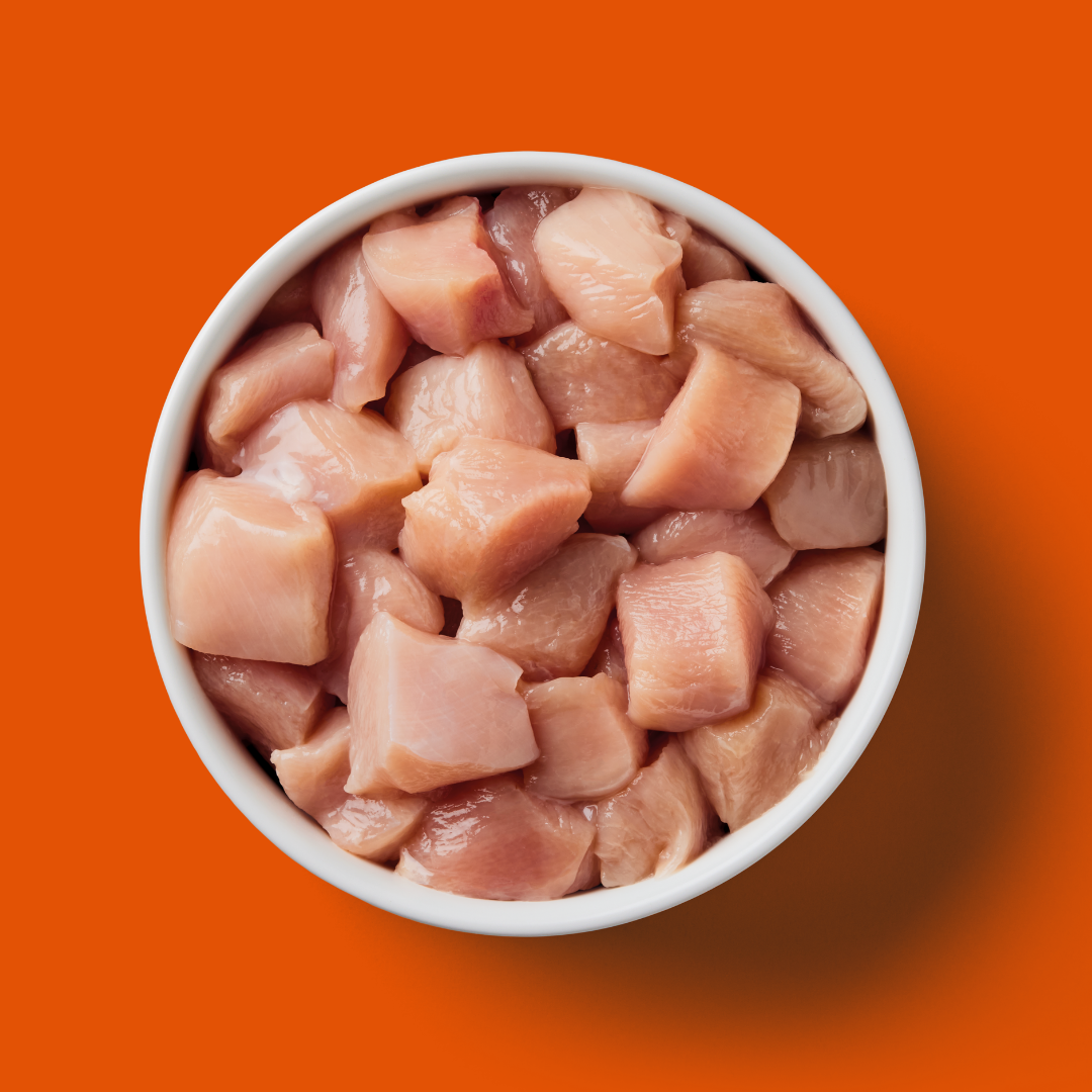 Just Raw Chicken 500g cubes on an orange background.