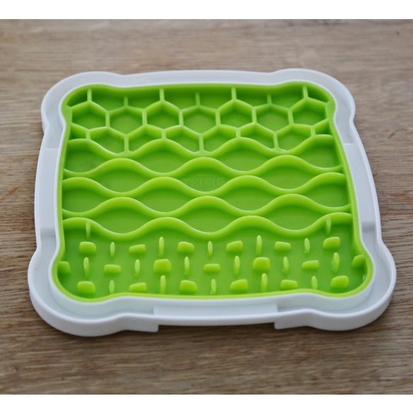 The Lick n Snack Licking Plate, with a white border, enhances mealtimes and enrichment on a wooden surface.