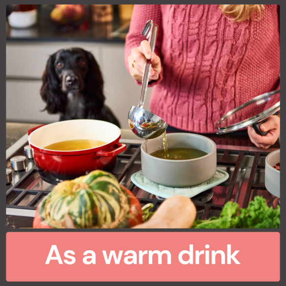 Person pours Beef Bone Broth 500ml into a bowl on the stove while a dog watches. Text: "A warming drink for joint health.