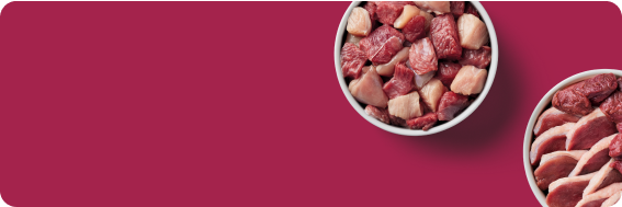 Two bowls filled with assorted raw meat pieces on a red background.