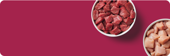 Two bowls of diced meat, one with red meat and the other with pink meat, on a pink background.