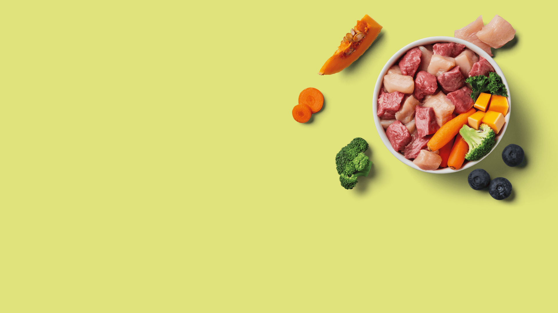 Raw meat and vegetables in a bowl on a green background