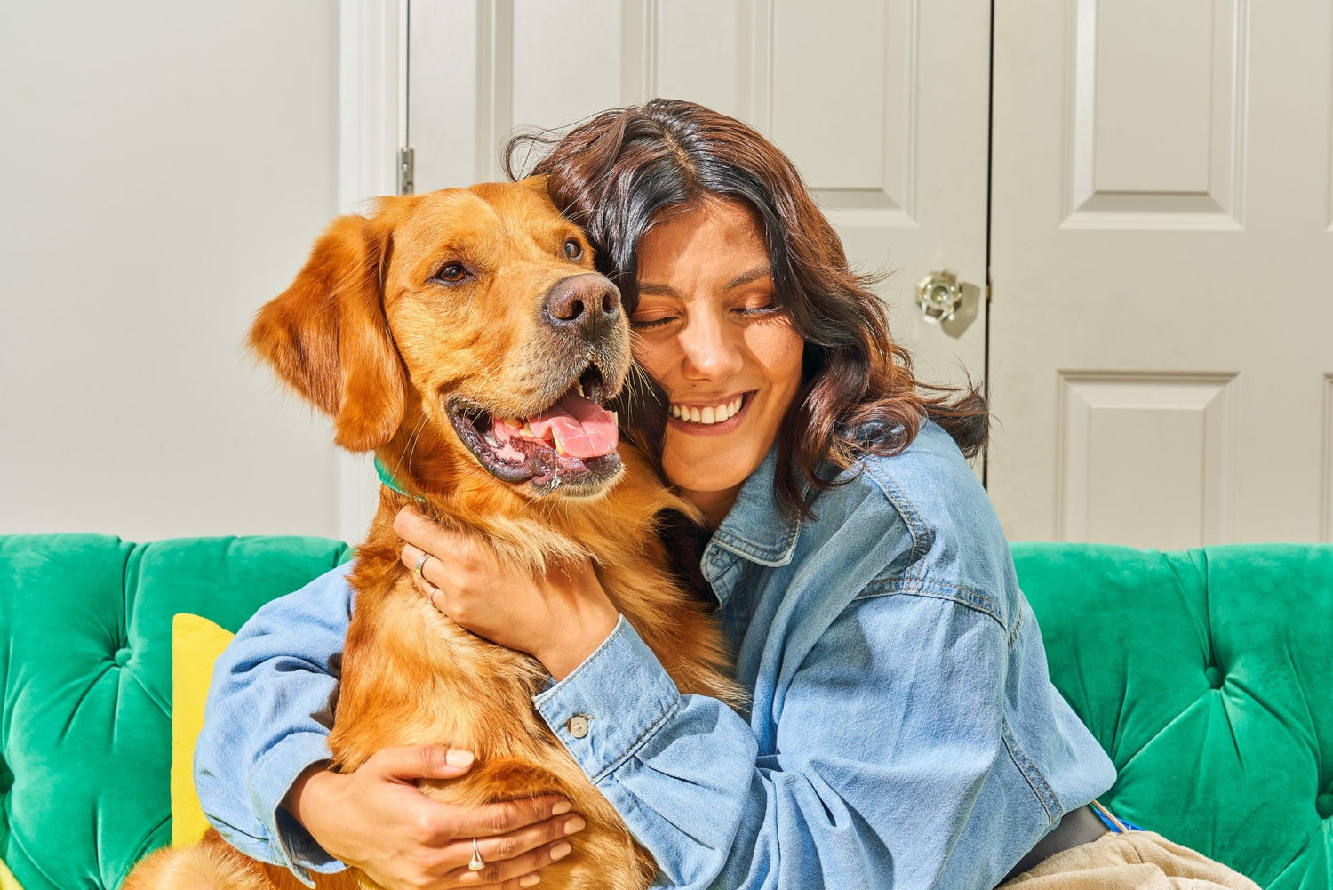 A woman cuddles a dog.