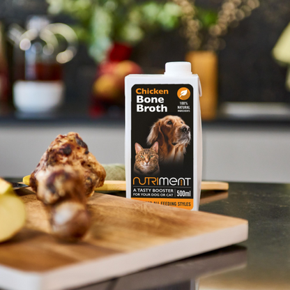 500ml Chicken Bone Broth for pets on a kitchen counter, great for gut health, with a bone on a cutting board.