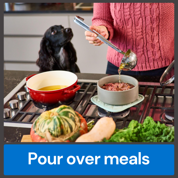 Person pouring Fish Bone Broth 500ml into a bowl for a dog, with vegetables beside the stovetop.