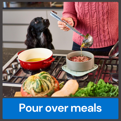 Person pouring Fish Bone Broth 500ml into a bowl for a dog, with vegetables beside the stovetop.